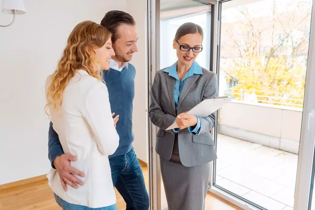 Landlady or realtor woman showing lease agreement to new tenants